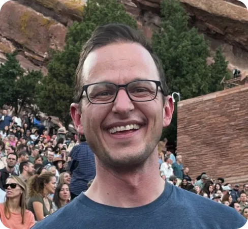 Warm outdoor portrait in natural light — real person, on-brand